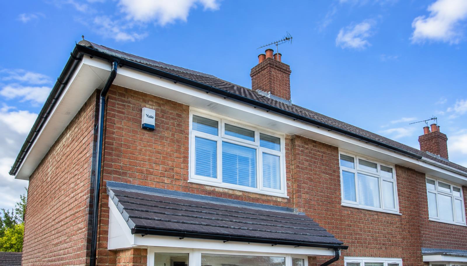 New white fascias and black guttering on a brick home